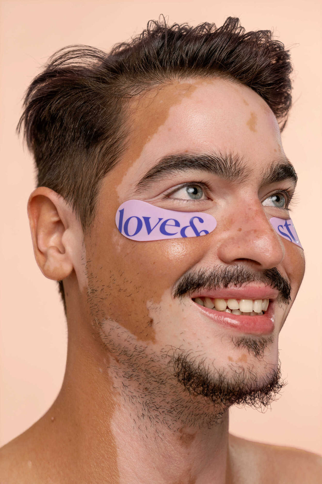 Young male model with vitiligo wearing the reusable eye patches by love&strife.