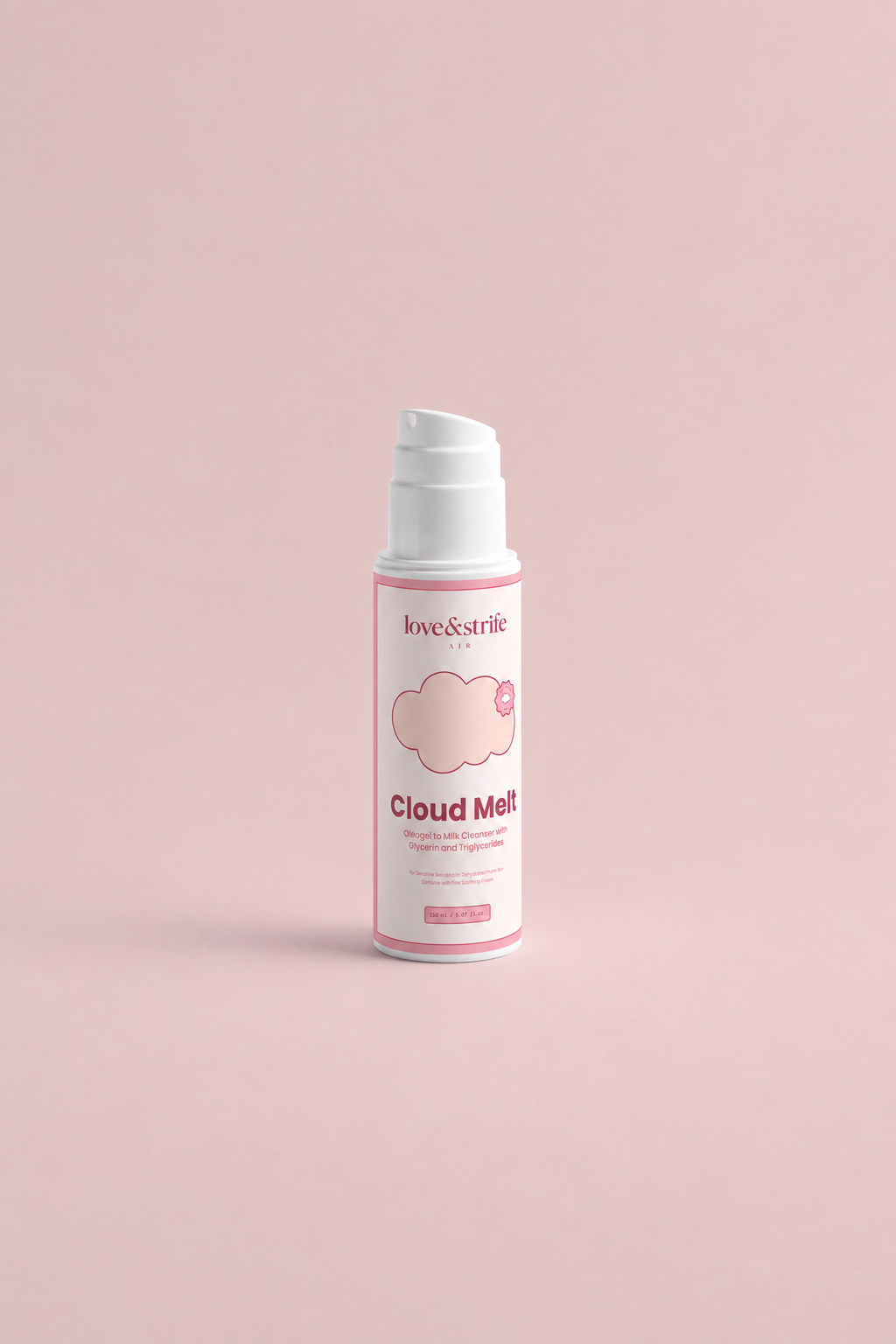 A white pump bottle of Love & Strife Cloud Melt milk cleanser with pink accents, set against a solid pale pink background.