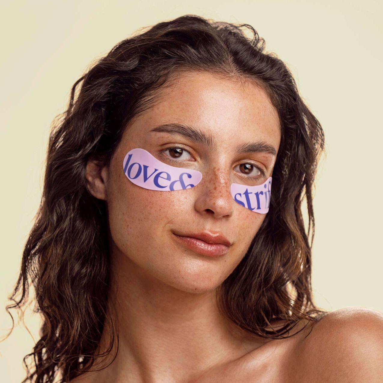 Woman looking directly at the camera, wearing the reusable eye patches.